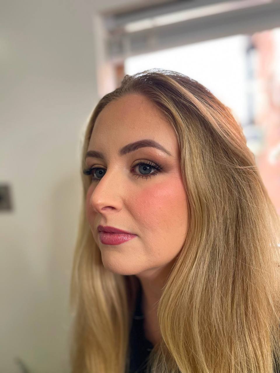 Soft glam makeup with warm blush and glossy lip
