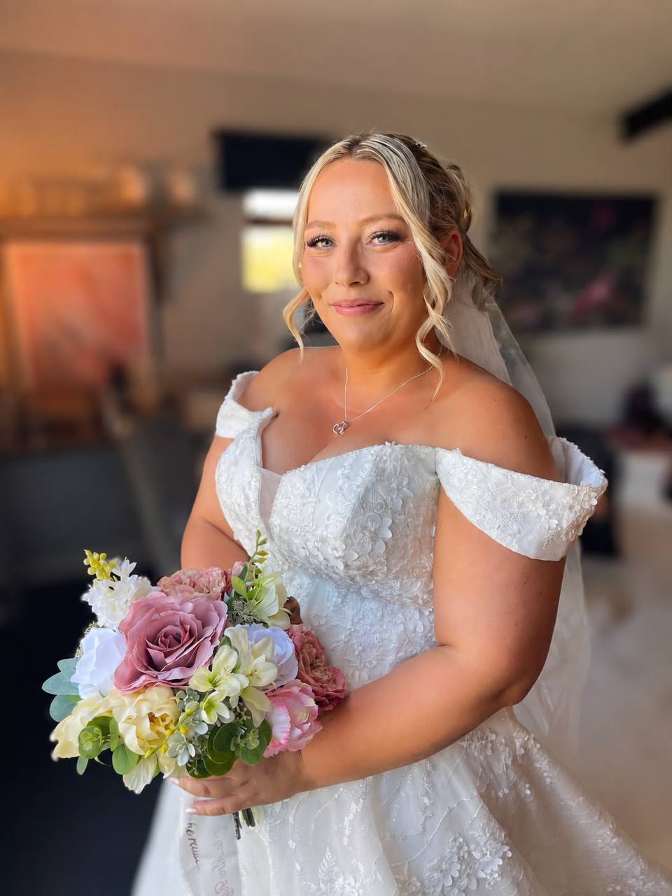 Bride in her dress holding a pastel bouquet
